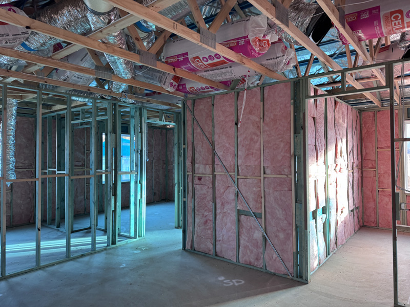 Pink wall batts in steel-framed walls and doorways of a new home