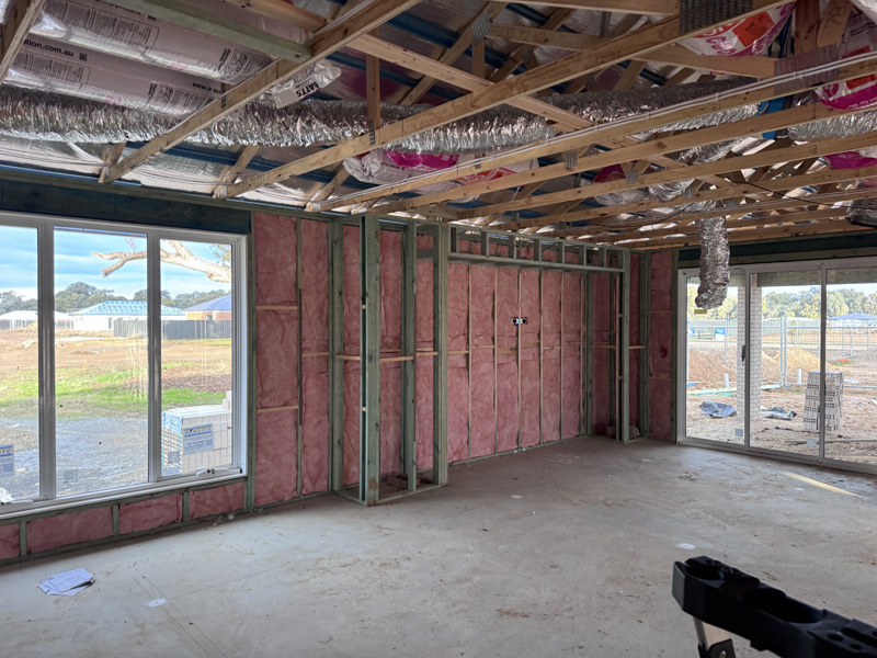 Pink wall batts in a large room of a new home with sliding doors and windows