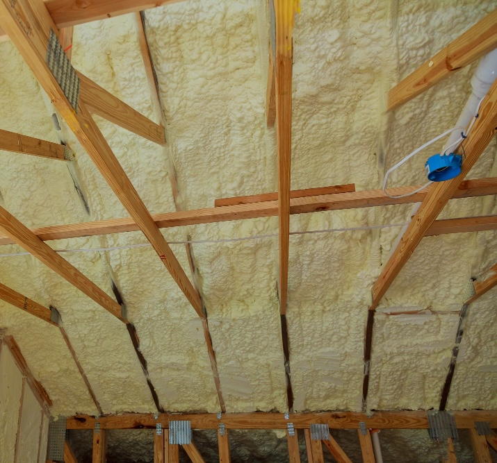 Spray foam insulation on a sloping ceiling between timber rafters